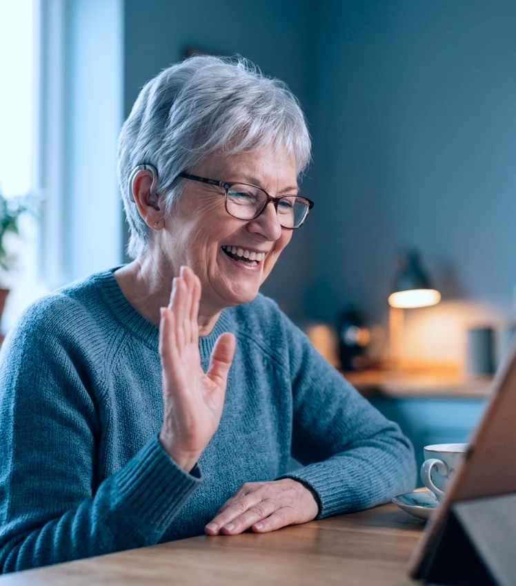 elderly woman smiling and waving